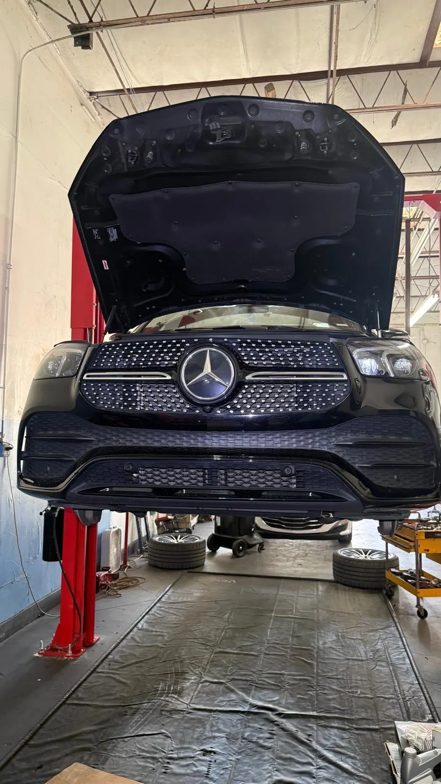 Mercedes GLE no elevador com o capô aberto na Phil's Electric Auto Expert em Pompano Beach