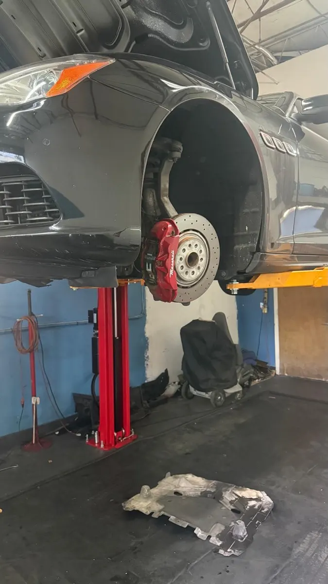 Pinça de freio vermelha e disco ventilado de uma Maserati em serviço de freios