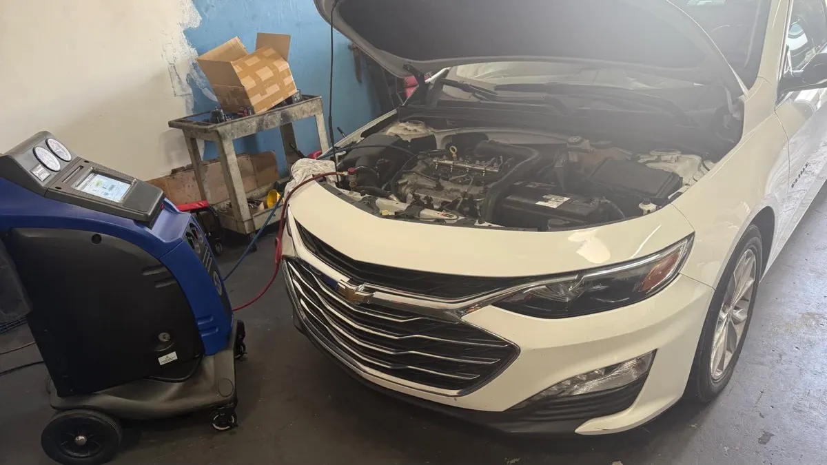 Máquina de recarga de ar-condicionado conectada a um carro durante o serviço